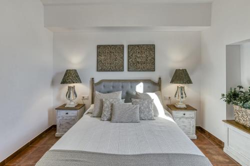 a bedroom with a large white bed with two night stands at Ca la Yaya in Llança