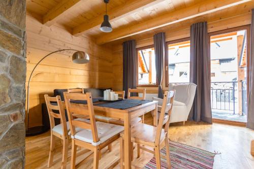 a dining room with a wooden table and chairs at Morcinowe Chałpy in Murzasichle