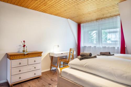 a bedroom with a bed and a dresser and a window at Himmelblau in Schönwald
