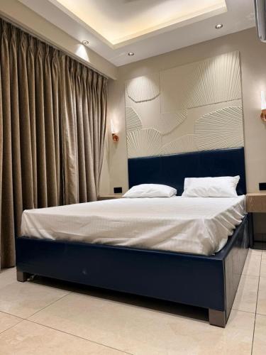 a bedroom with a large bed with a blue headboard at Town Centers in Ghaziabad