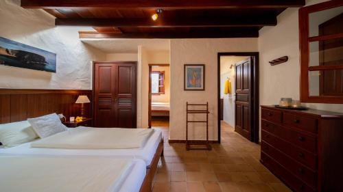 a bedroom with a bed and a dresser and a bathroom at Casa Margarita 4 in Mala