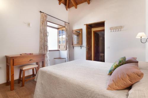 a bedroom with a bed and a desk and a window at Volcán 18 in Tanque