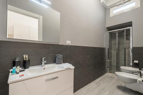 a bathroom with a sink and a toilet and a mirror at Dimora Cece in Francavilla Fontana