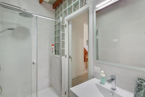 a white bathroom with a shower and a sink at Loft Noemi - La Aldea in San Nicolás