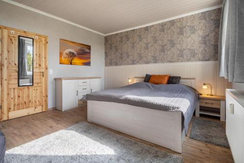 a bedroom with a bed and a desk and a window at Landglück in Hohenmocker