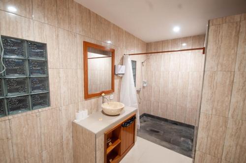 a bathroom with a sink and a shower at Rumah Gajah by Kubukubali in Pemuteran