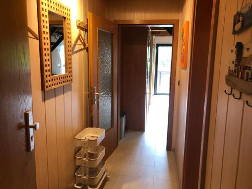 a hallway with a bathroom with a mirror and a door at Ferienwohnung Borkum in Burhave