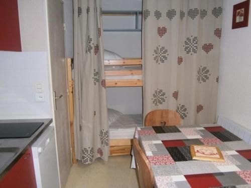 a small room with a bed and a kitchen at Appartement Le Relais Du Devoluy in Le Dévoluy