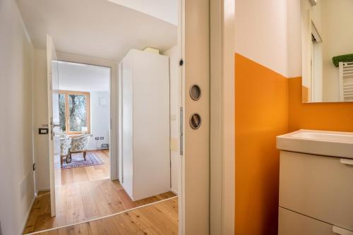 a small kitchen with orange walls and a hallway at Villa Iagra in Tiarno di Sopra