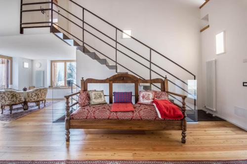 a room with a bed with pillows and a staircase at Villa Iagra in Tiarno di Sopra
