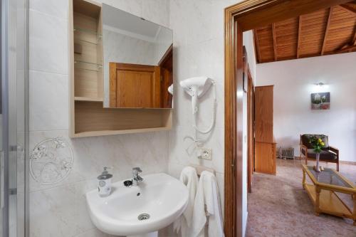 a white bathroom with a sink and a shower at Casa Zaida Olivos in San Sebastián de la Gomera