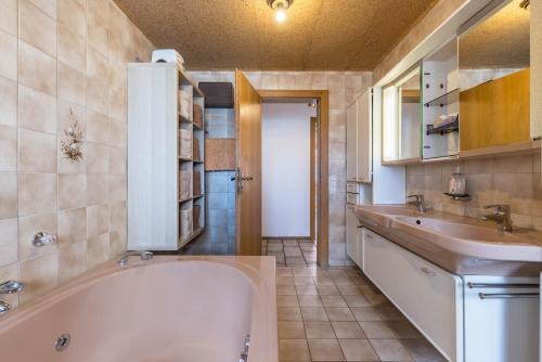 a bathroom with a tub and a sink at Große Ferienwohnung Wagner in Wehingen