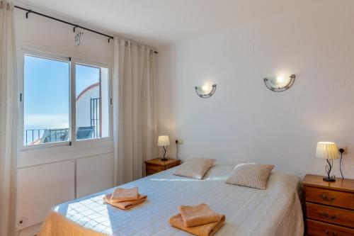 a bedroom with a bed with two towels on it at 180-degrees sea view with pool in Benitachell