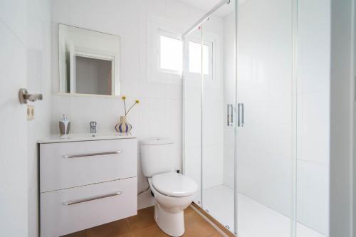 a white bathroom with a toilet and a shower at Casa Yolima in Sóller