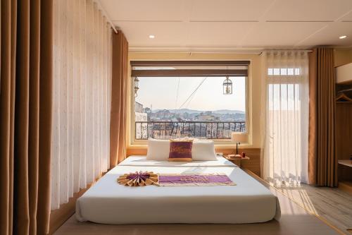 a bedroom with a large bed with a large window at Sweet Lavender Hotel - Ngay chợ đêm Đà Lạt in Da Lat