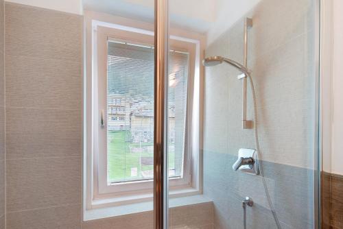 a bathroom with a shower and a window at Appartamento Primavera 1 in Moena