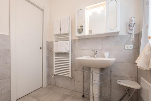 a white bathroom with a sink and a mirror at Il grappolo monolocale in Sirmione