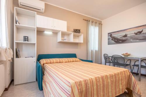 a small bedroom with a bed and a table at Il grappolo monolocale in Sirmione