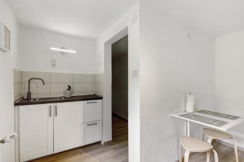 a white kitchen with white cabinets and a sink at Fewo Schober in Kirchhundem