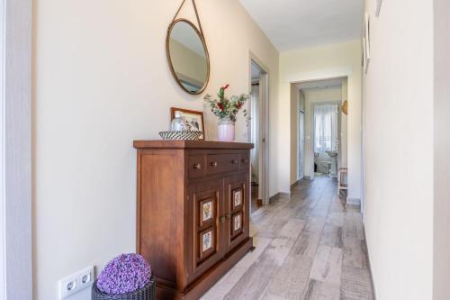 a hallway with a dresser and a mirror on a wall at Brizna in Oreña