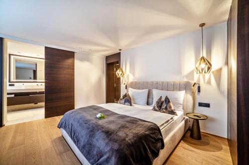 a bedroom with a large bed and a bathroom at Schenna Chalet - Apt Dora in Schenna