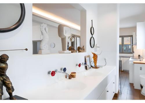 a white kitchen with a counter with sculptures on it at Luna Rossa Milos - Olive Home in Provatas
