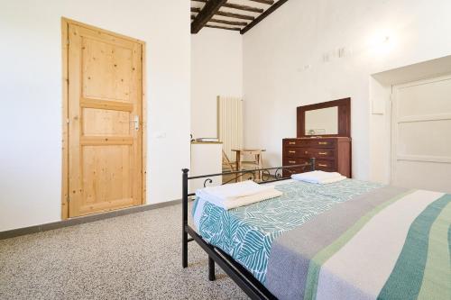 a bedroom with a bed and a dresser and a door at Il Podere Del Ponti - Paduletto in Casa Paduletto