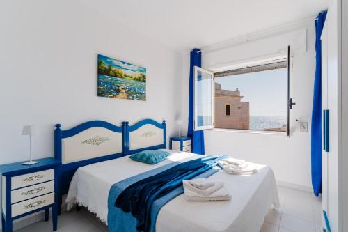 a blue and white bedroom with a bed and a window at Olimpia's home in Otranto in Otranto