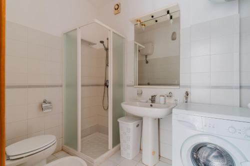 a bathroom with a toilet sink and a washing machine at Olimpia's home in Otranto in Otranto