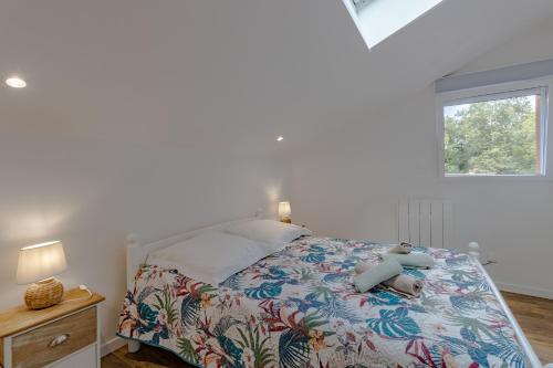 a bedroom with a bed and a window at La Villa du Mas des Chenes in Pomport