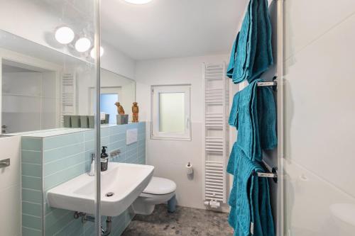 a bathroom with a sink and a toilet at Höhe26 in Bad Vilbel