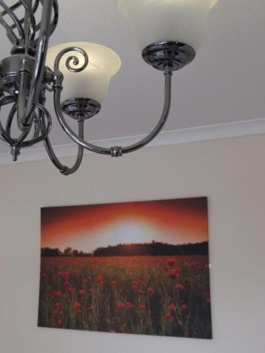a chandelier and a picture of a field of flowers at The Monsell Hotel in Skegness