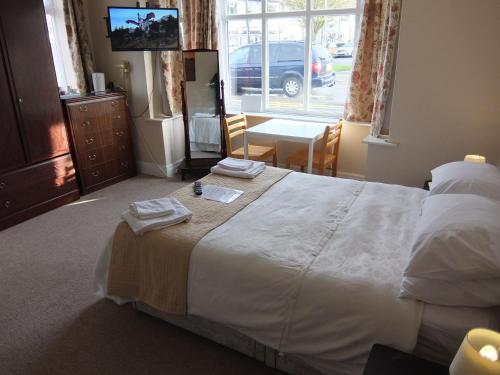a bedroom with a large bed with towels on it at The Monsell Hotel in Skegness