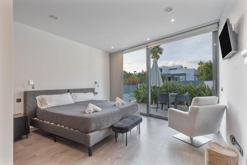 a bedroom with a king sized bed and a balcony at Villa Elite Maribiza in Cala Llena