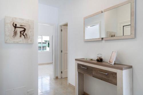 a white room with a mirror and a wooden table at Apartamento Seaview Limones in Playa Blanca