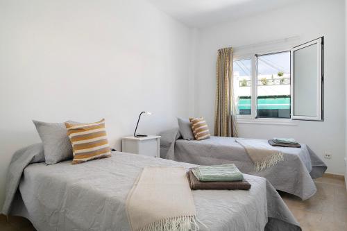 a white room with two beds and a window at Apartamento Seaview Limones in Playa Blanca