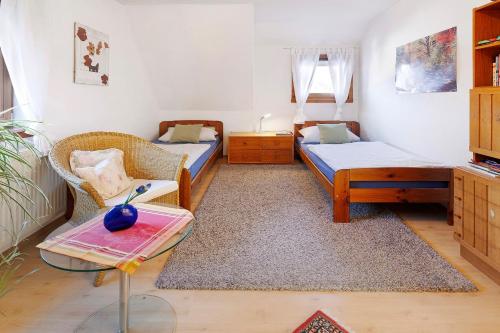 a small room with two beds and a table at Ferienwohnung Birkenberger in Löffingen