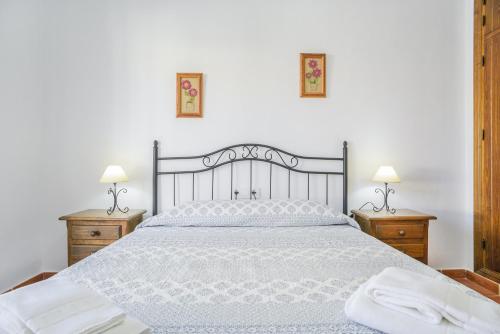 a bedroom with a large white bed with two night stands at Casa Villanueva 2 - Sólo Familias in Conil de la Frontera