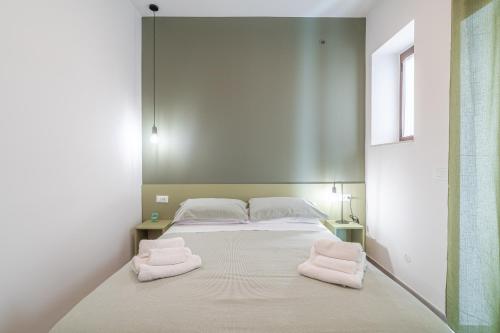 a bed with two towels on it in a room at La Casetta del Cuore in Noto