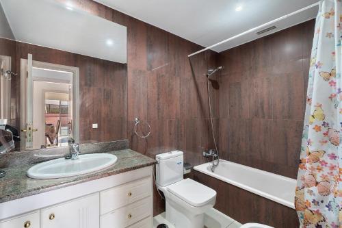 a bathroom with a toilet and a sink and a tub at terrazas del duque fase2 in Adeje