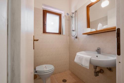 a bathroom with a white toilet and a sink at Rosaspina - Appartamento 6 in Capalbio