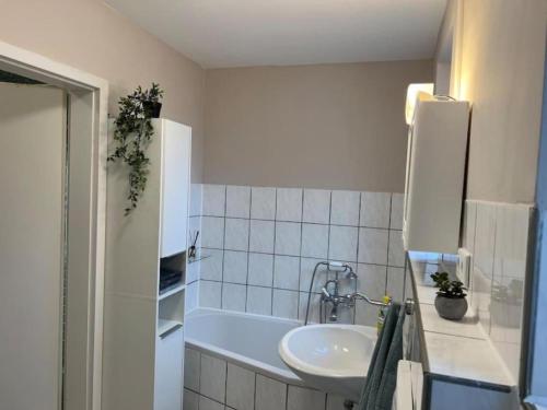 a bathroom with a sink and a tub and a sink at Geräumiges Haus Mit Viel Platz in Jübek