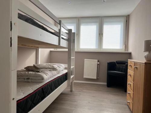 a bedroom with a bunk bed and a couch at Geräumiges Haus Mit Viel Platz in Jübek