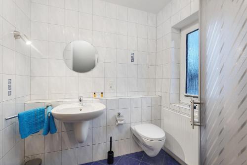 a white bathroom with a toilet and a sink at Ferienwohnung Westfeld in Bestwig