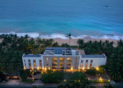 a view of a hotel with the ocean in the background at The Rockwall Boutique Hotel Bentota in Bentota