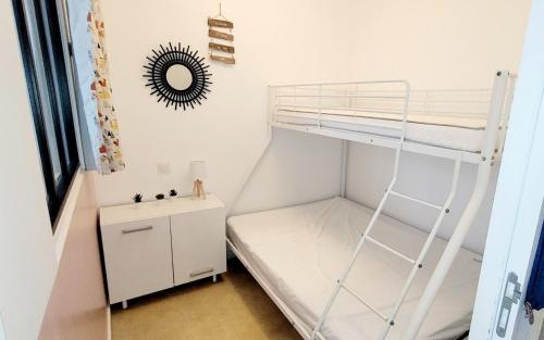 a small bedroom with a bunk bed and a desk at L'appartement De La Forêt in La Tranche-sur-Mer