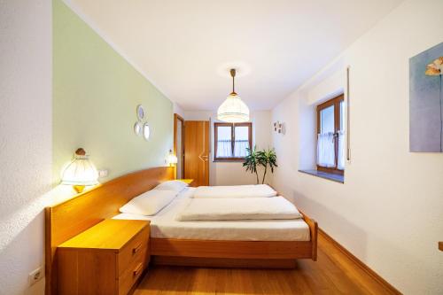 a bedroom with two beds and two windows at Wohnung Gravensteiner Schnalserhof in Laces