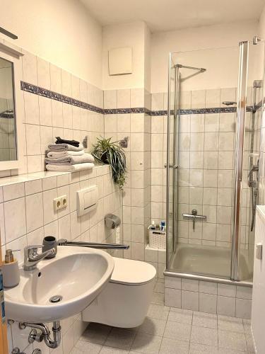 a white bathroom with a sink and a shower at Fewo Seehaase in Radolfzell am Bodensee