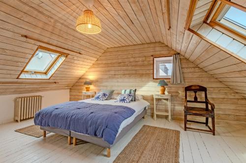 a bedroom with a bed and a wooden ceiling at Ty Abéric maison en front de mer in Ploudalmézeau