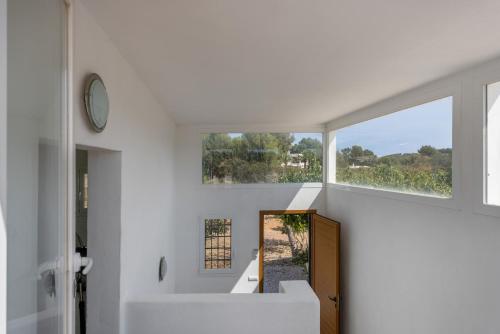 a white bathroom with a sink and a window at Finca Can Paci in Santa Eularia des Riu